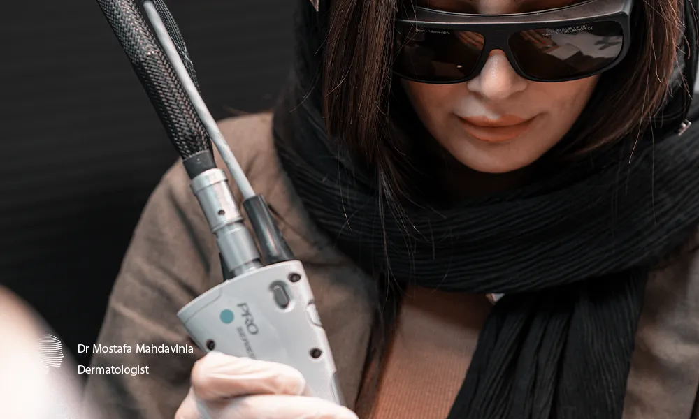 اپراتور لیزر موهای زائد کلینیک دکتر مهدوی نیا در حال لیزر موهای زائد دست مراجعه کننده