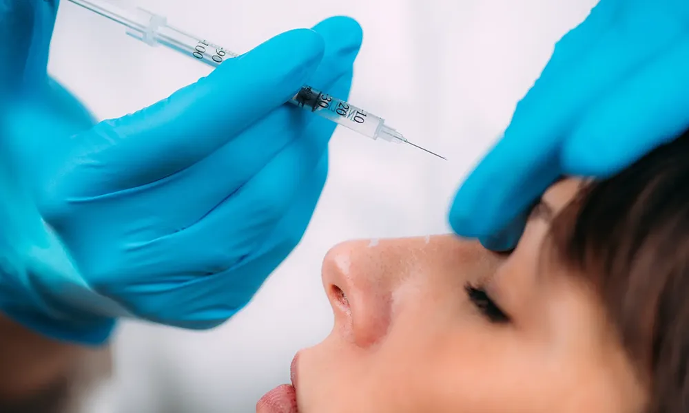 پزشک با دستکش های آبی در حال تزریق فیلر خط اخم برای یک خانم با چشمان بسته